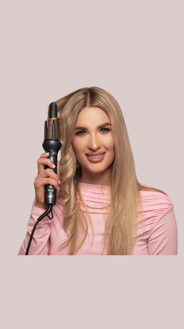 Woman holding a G&C automatic curler hair curling iron against a light pink background